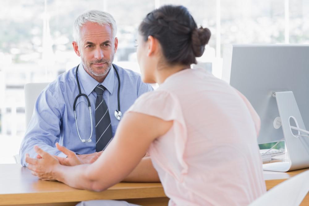 a woman is speaking with her doctor across the table about her experience with semaglutide in memphis