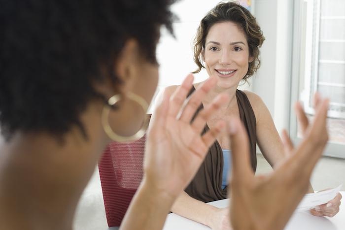 two healthy, happy women speak with one another at a table about semaglutide in memphis