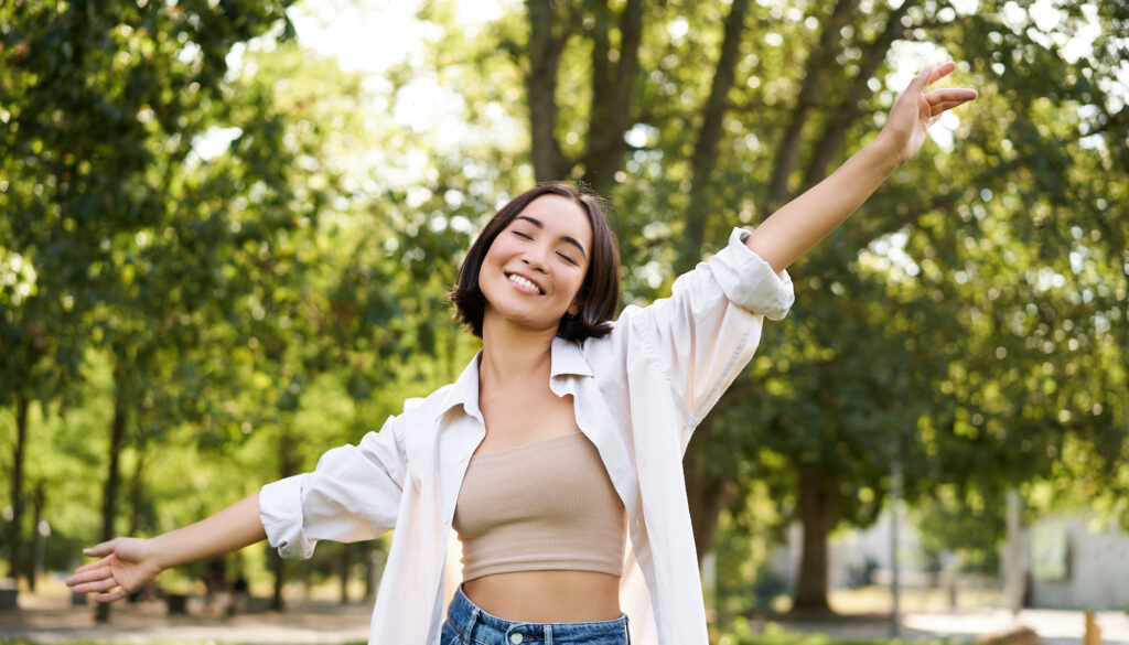 carefree woman dancing in the park