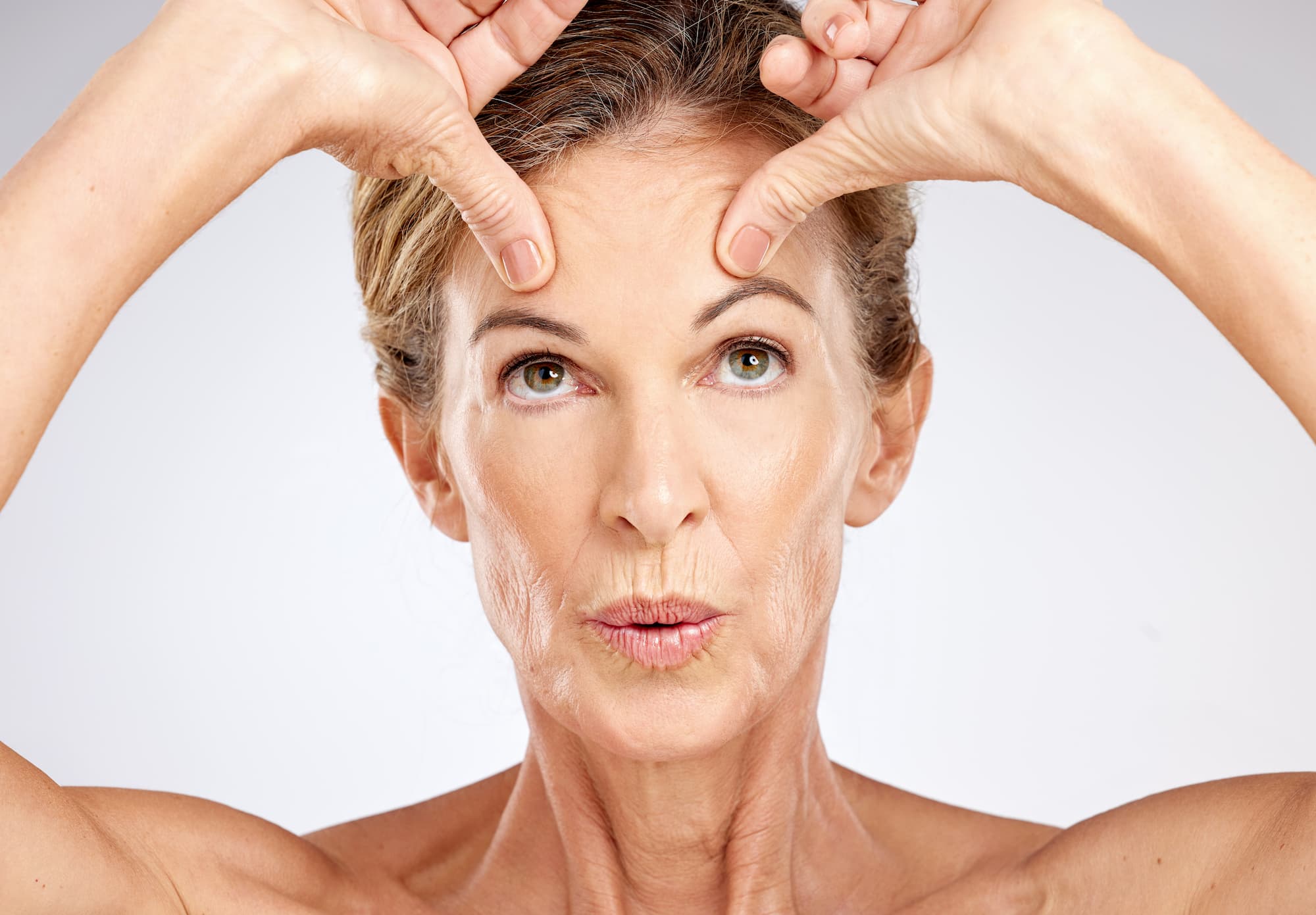 a senior woman trying facial exercise for skin tightness