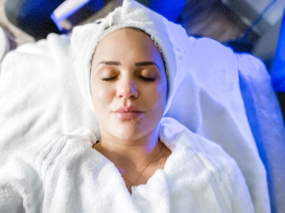 A woman lying down in med spa attire relaxing after IPL treatment in Memphis